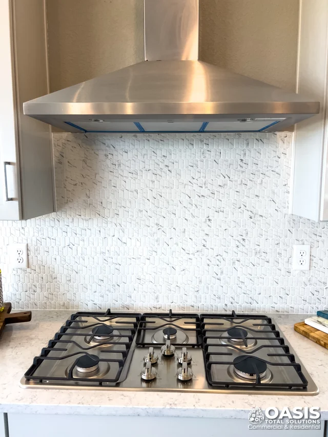 Installed gas cooktop with stainless hood