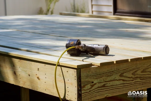 Air nailer resting on new pressure-treated deck boards
