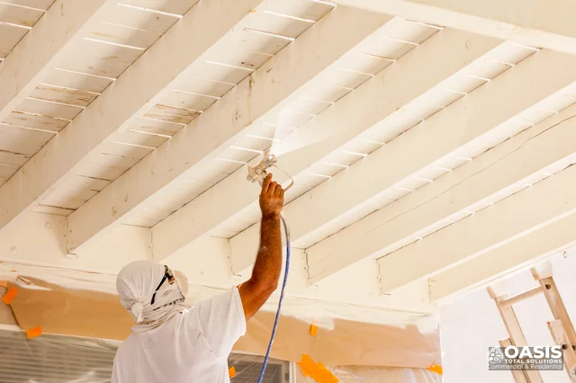 Spraying paint under deck joists