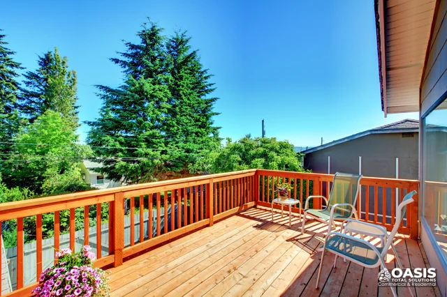 Sunny wood deck with lounge chairs and railing