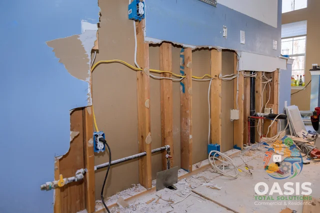 Kitchen wall opened for rough-in; electrical and plumbing visible