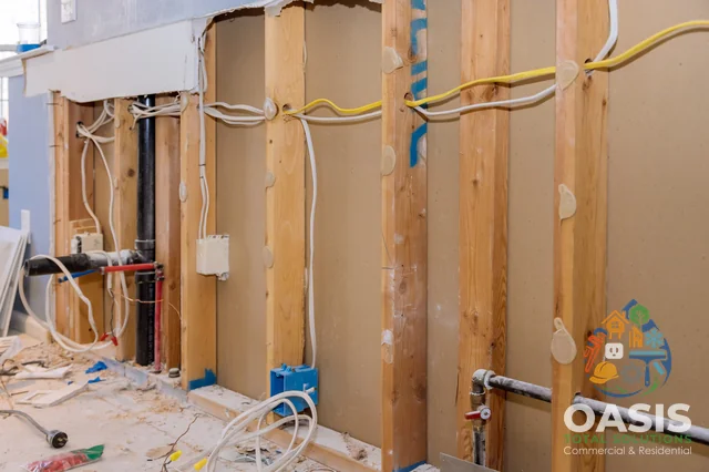 Kitchen wall opened—rough electrical and plumbing visible
