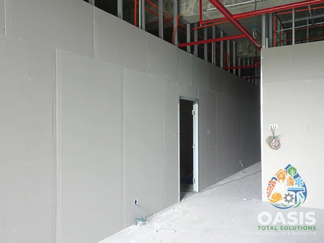 Commercial corridor with drywall installed and door opening