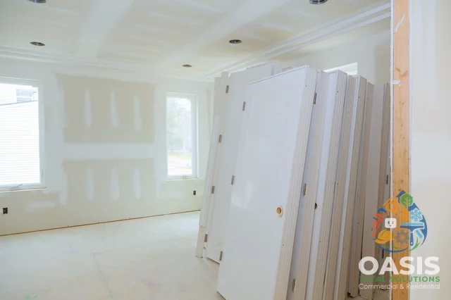 Drywalled room with pre-hung doors staged for installation