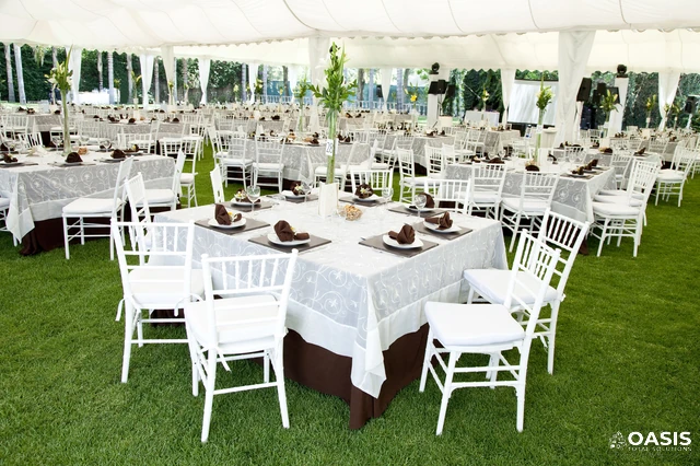 Outdoor wedding reception setup under white marquee