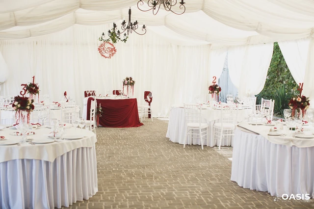 Elegant wedding tent with white draping and red accents