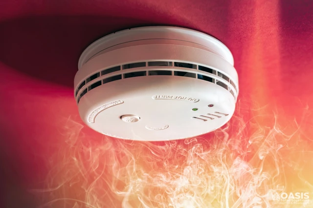 Smoke rising toward a ceiling-mounted smoke detector