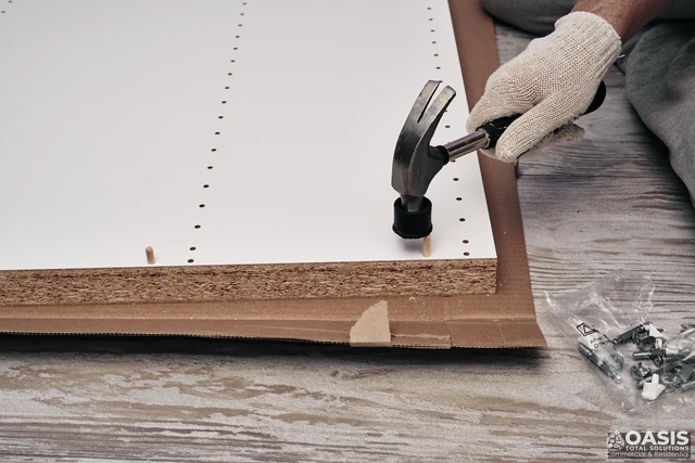 Hammering dowel pins into cabinet panel