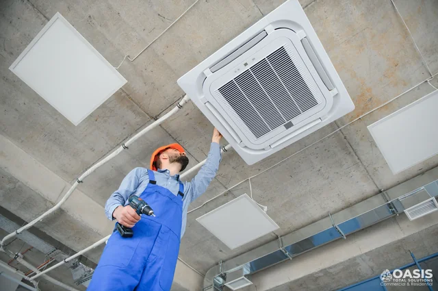 Technician checking ceiling cassette AC