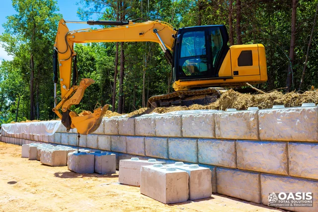 Excavator placing large wall blocks