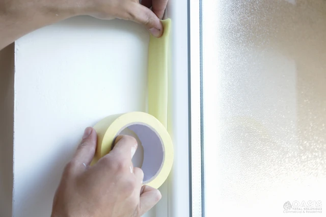 Applying masking tape around a window frame