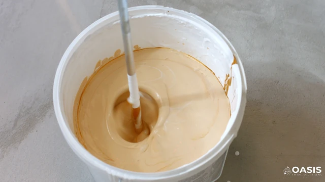 Mixing paint in a bucket with a drill mixer
