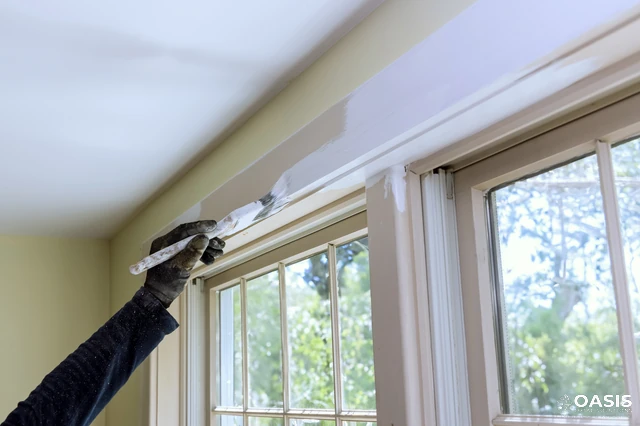 Hand brushing fresh paint on interior window trim