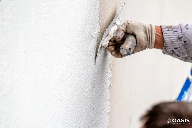 Applying skim coat with a trowel on interior wall