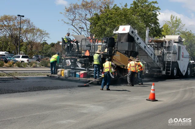 Crew paving a parking lot with an asphalt paver