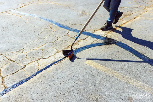 Crack sealing with hot rubber using a V-shaped squeegee