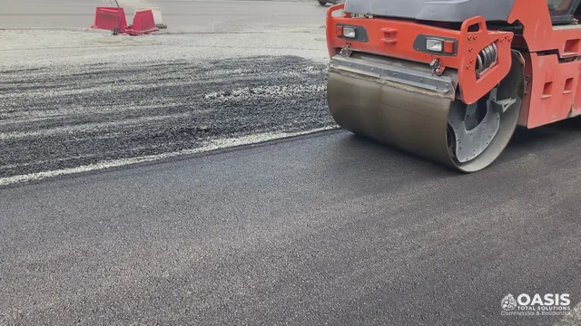 Drum roller compacting a fresh asphalt lift