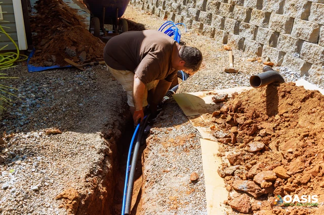 Technician laying water line in exterior trench