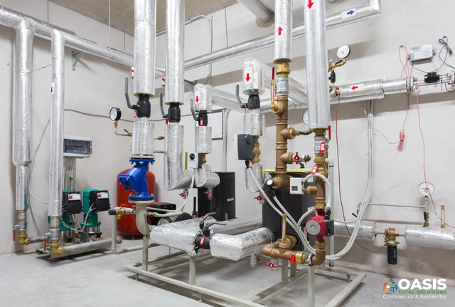 Hydronic mechanical room with insulated pipes and pumps