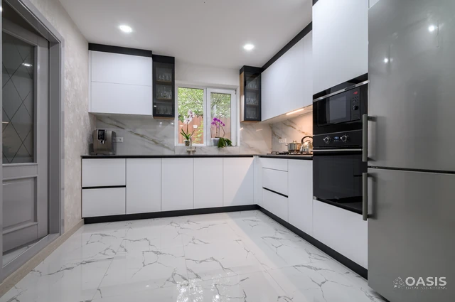 Clean white kitchen design with large-format marble tiles