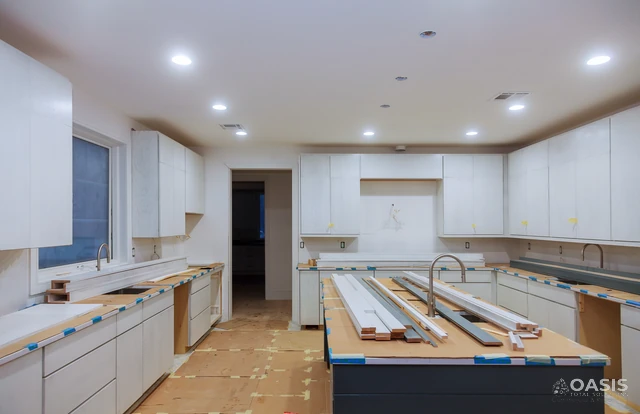 Wide kitchen under construction with cabinets and large island