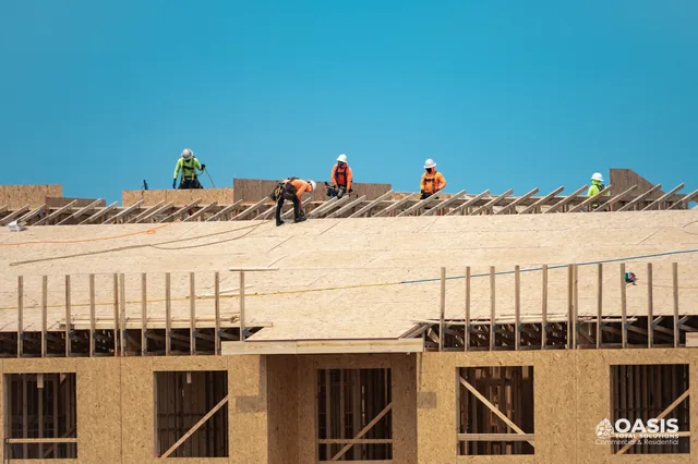 Crew building a large roof deck on new construction framing