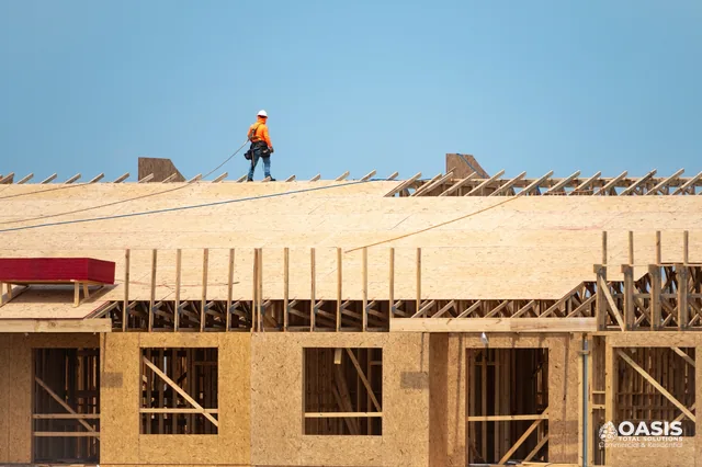 Roofer walking on plywood sheathing during roof build
