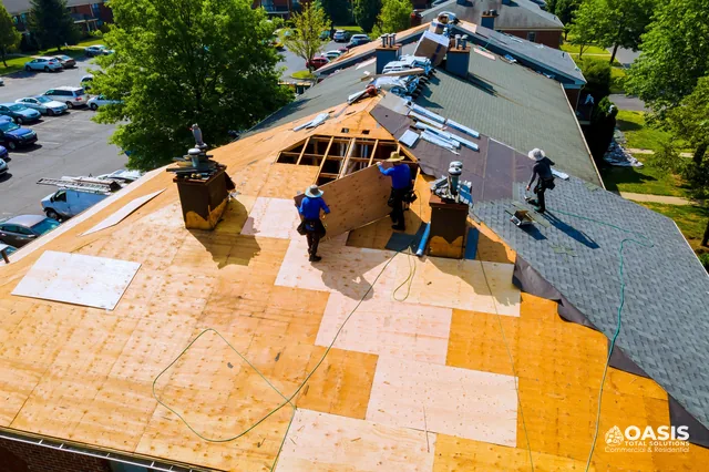 Aerial view of crew replacing roof deck with new plywood sheathing