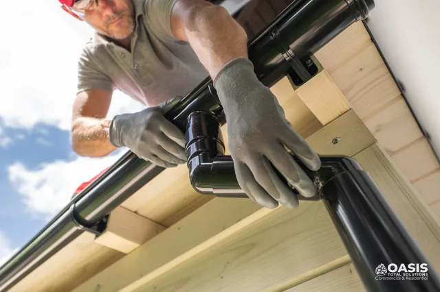 Installing a black aluminum gutter elbow on fascia