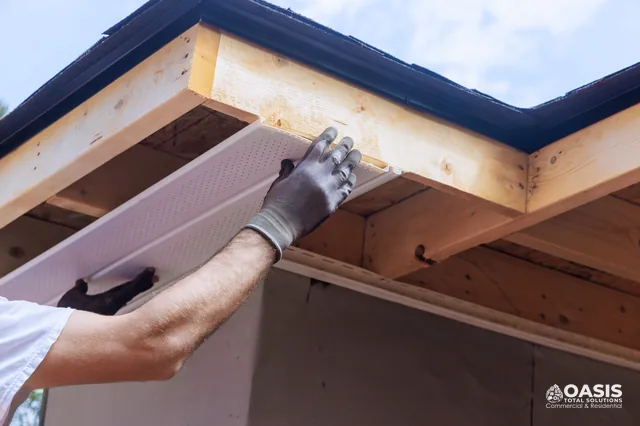 Installing a white vented soffit panel under the eave for airflow