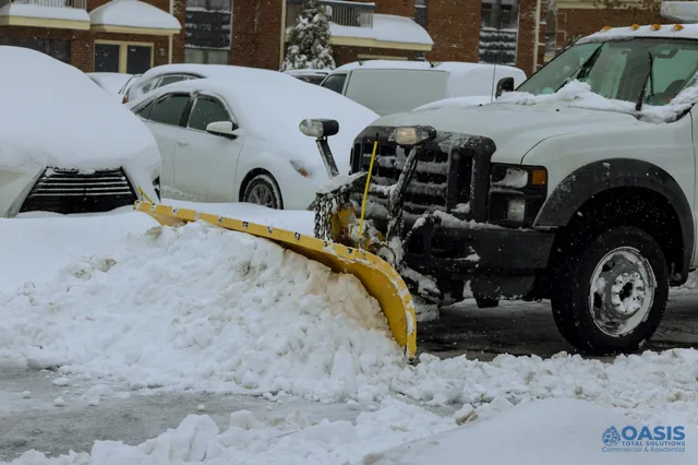 Pickup truck with plow clearing a parking lot