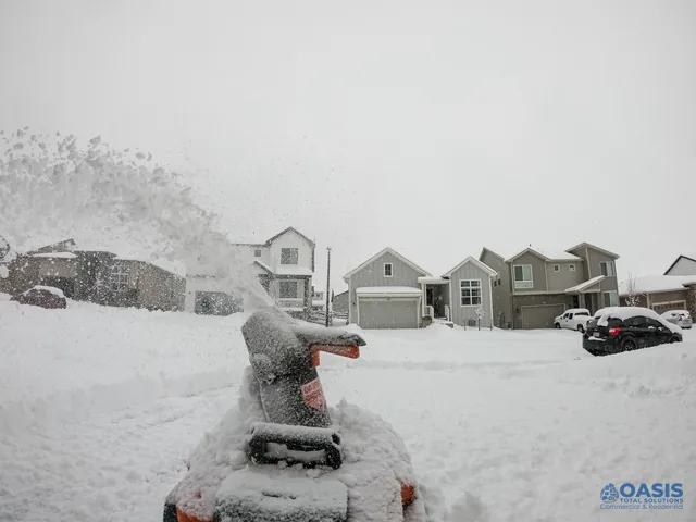 Snow blower throwing fresh powder on a residential street