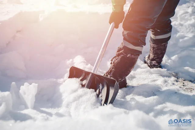 Worker shoveling fresh snow with an ergonomic shovel