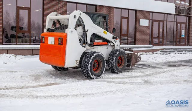 Skid-steer parked after plowing at a commercial site