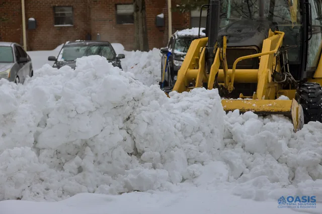 Front loader pushing a heavy snow pile in a lot