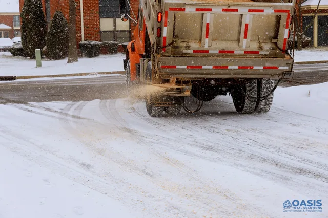 Salt truck spreading material on a snowy residential street