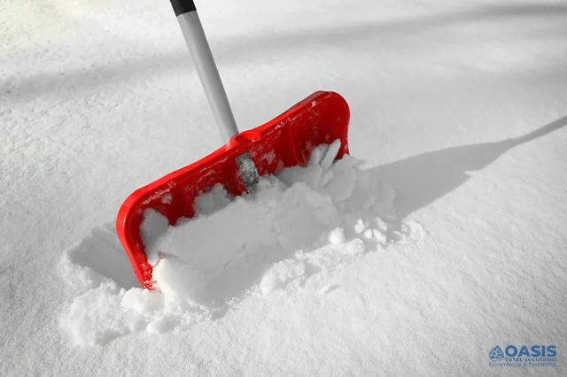Red snow shovel pushing fresh powder